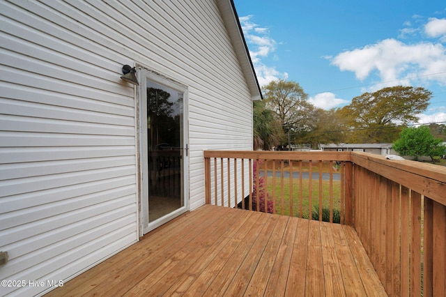 wooden deck featuring a lawn
