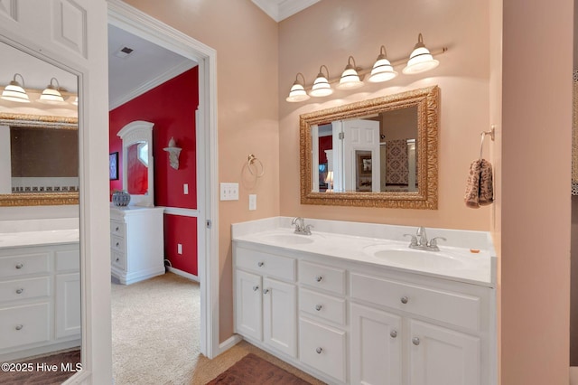 full bathroom with double vanity, ornamental molding, a sink, and baseboards