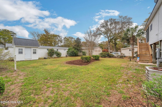 view of yard featuring a garage, cooling unit, and stairway