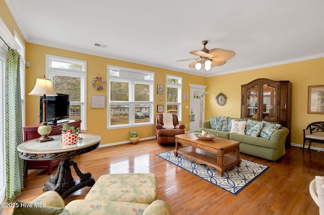 living area featuring hardwood / wood-style floors, ornamental molding, and ceiling fan