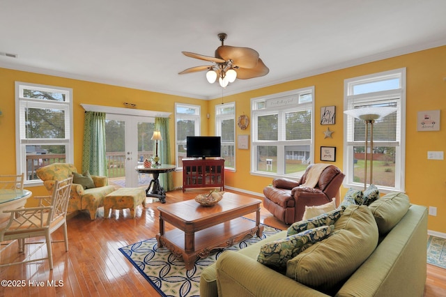 living area featuring crown molding, a ceiling fan, french doors, and wood-type flooring