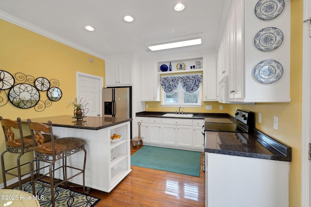 kitchen featuring stainless steel fridge, open shelves, a sink, white cabinets, and white microwave