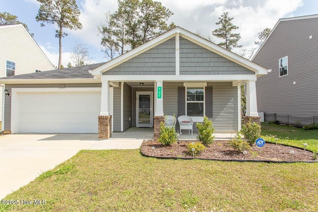 craftsman house featuring a porch, an attached garage, concrete driveway, and a front lawn