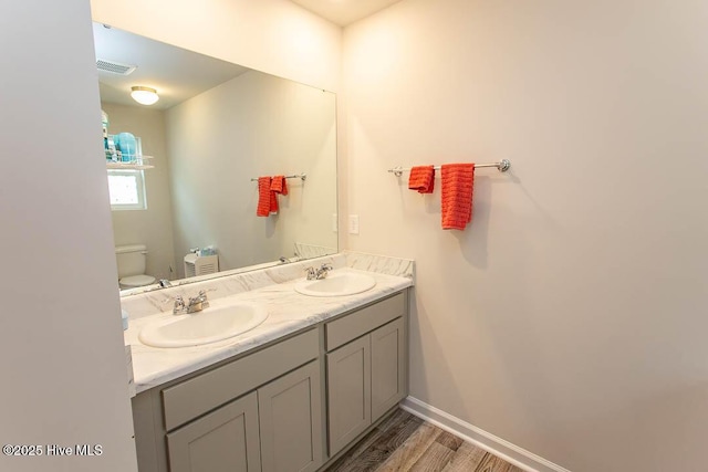 bathroom featuring visible vents, baseboards, a sink, and toilet