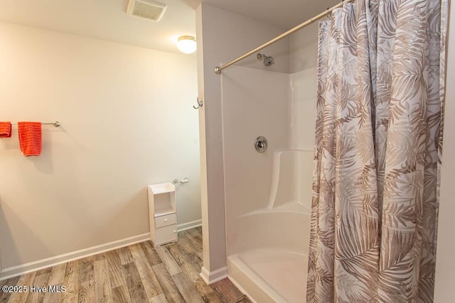 full bathroom featuring visible vents, baseboards, a shower with curtain, and wood finished floors