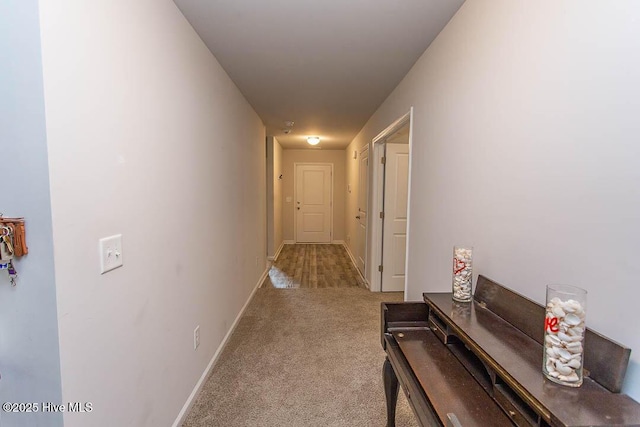 hallway featuring baseboards and carpet floors