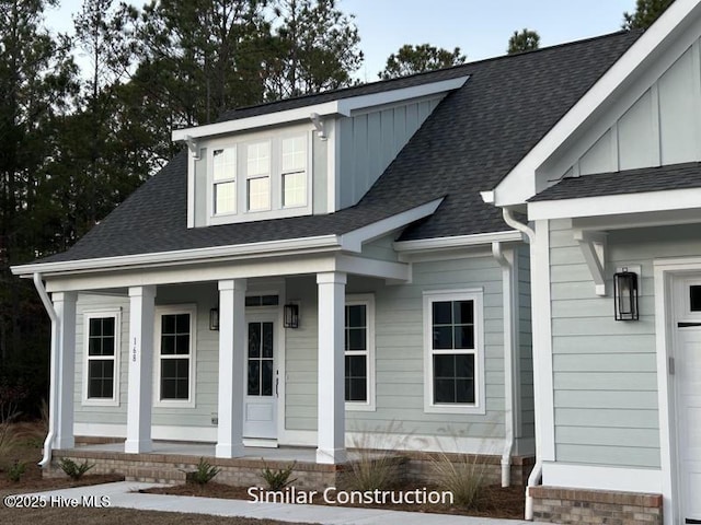 179 N Brightleaf Dr, Minnesott Beach, NC 28510 - view of front of property featuring a porch, board and batten siding, a shingled roof, and a garage