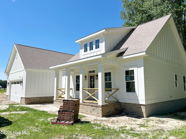 179 N Brightleaf Dr, Minnesott Beach, NC 28510 - modern farmhouse style home with covered porch, board and batten siding, roof with shingles, and a garage