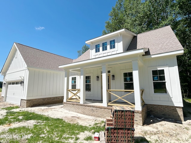 179 N Brightleaf Dr, Minnesott Beach, NC 28510 - modern farmhouse with board and batten siding, a porch, roof with shingles, and a garage