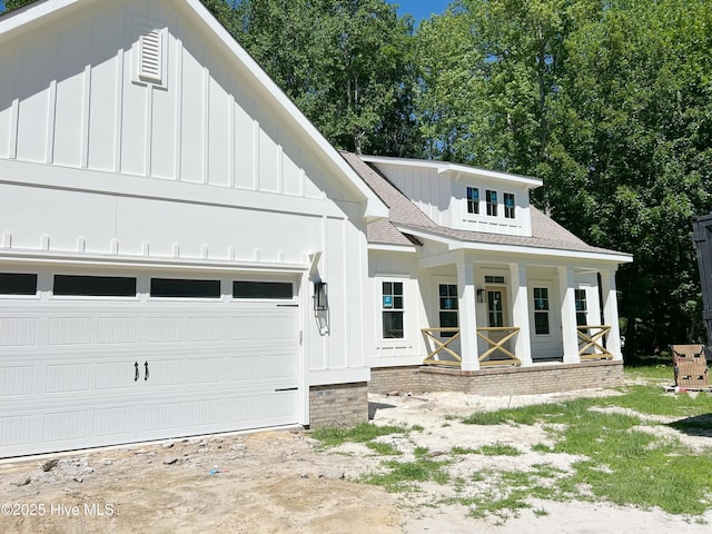 179 N Brightleaf Dr, Minnesott Beach, NC 28510 - modern farmhouse style home with board and batten siding, covered porch, a shingled roof, driveway, and a garage