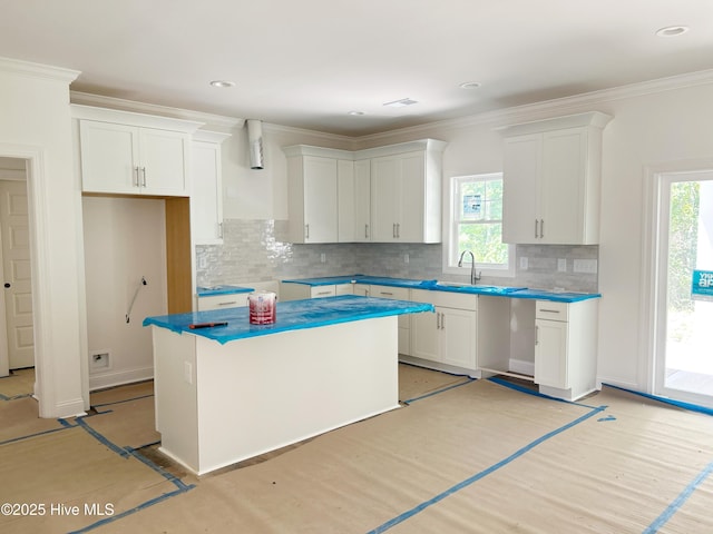 179 N Brightleaf Dr, Minnesott Beach, NC 28510 - kitchen with backsplash, a sink, a kitchen island, white cabinetry, and plenty of natural light