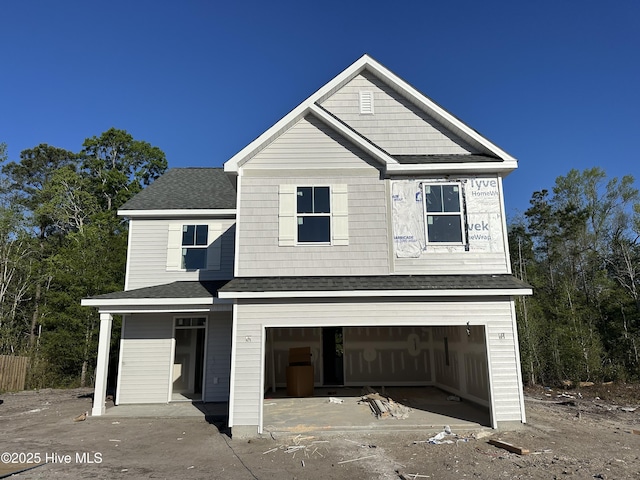 view of front of house featuring an attached garage and a shingled roof