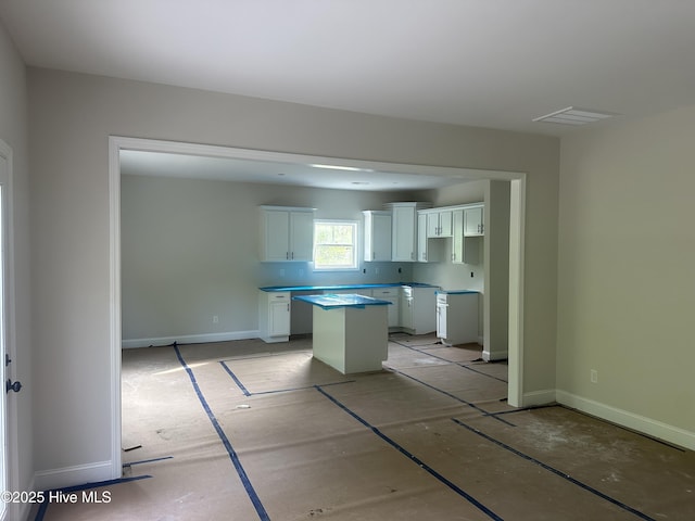 610 Poppleton Dr, Hampstead, NC 28443 - kitchen featuring white cabinetry, baseboards, visible vents, and a center island