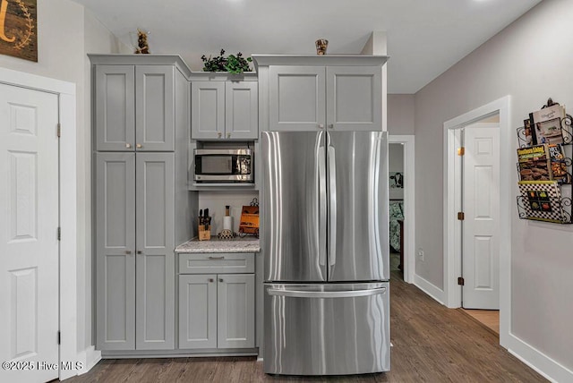 1560 White Oak River Rd, Maysville, NC 28555 - kitchen with appliances with stainless steel finishes, gray cabinetry, baseboards, dark wood-style floors, and light stone countertops