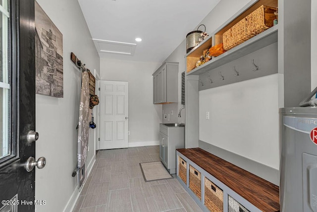 1560 White Oak River Rd, Maysville, NC 28555 - mudroom featuring attic access, water heater, a sink, and baseboards