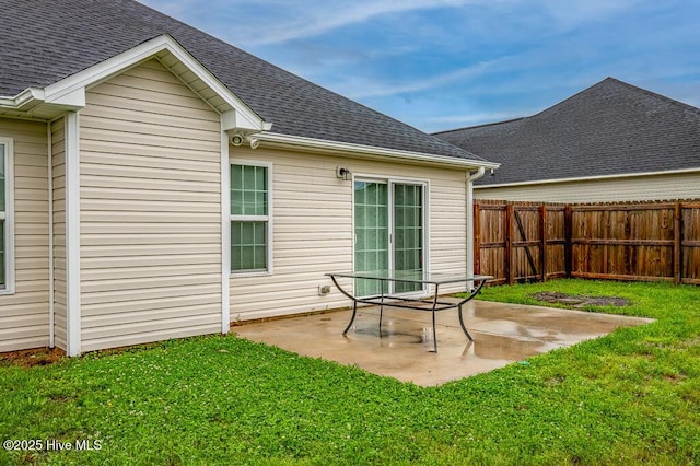 rear view of property featuring a shingled roof and a patio area