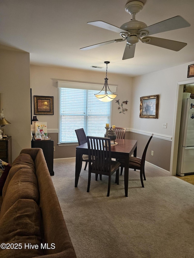 dining room featuring ceiling fan and carpet