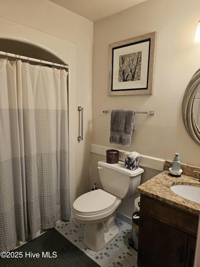 bathroom with vanity, curtained shower, toilet, baseboards, and tile patterned floors