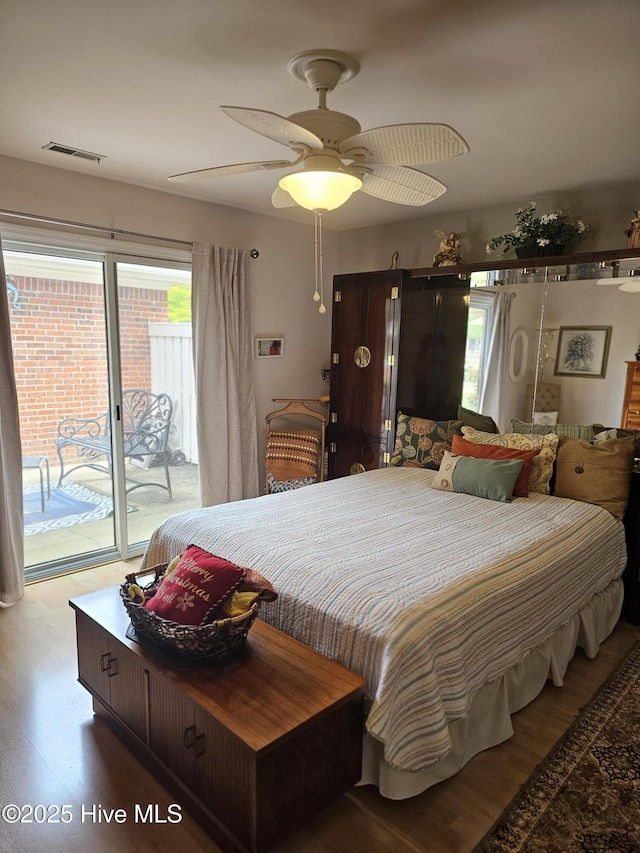 bedroom featuring ceiling fan, visible vents, access to exterior, and wood finished floors
