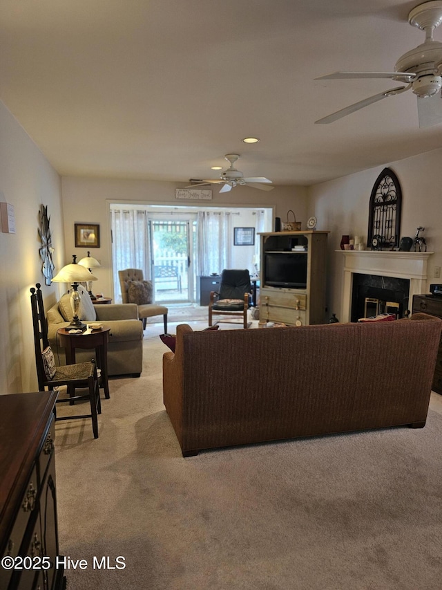 living room featuring a ceiling fan, recessed lighting, light carpet, and a fireplace