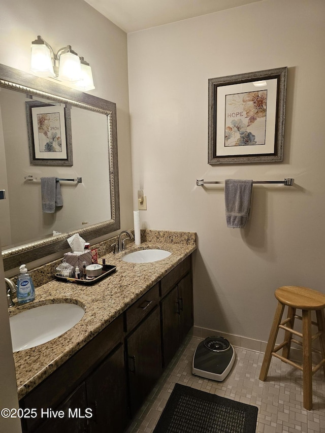 bathroom with baseboards, a sink, tile patterned floors, and double vanity