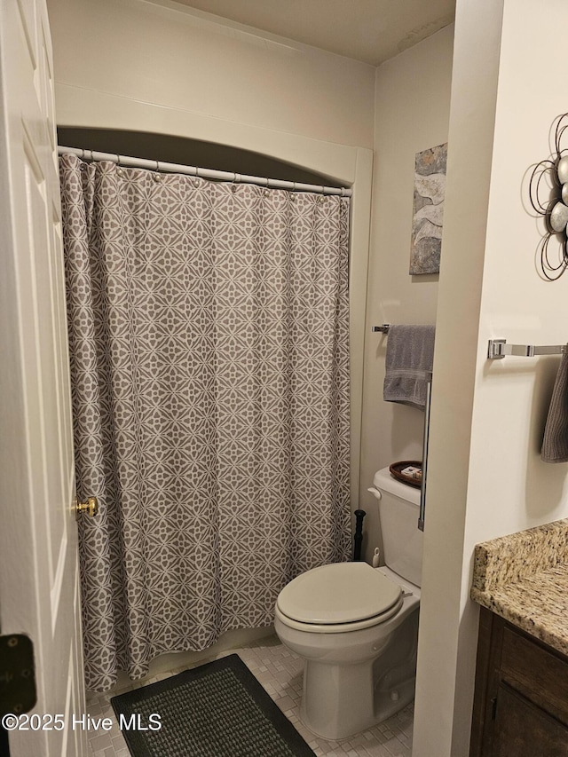 bathroom with vanity, tile patterned floors, toilet, and a shower with curtain
