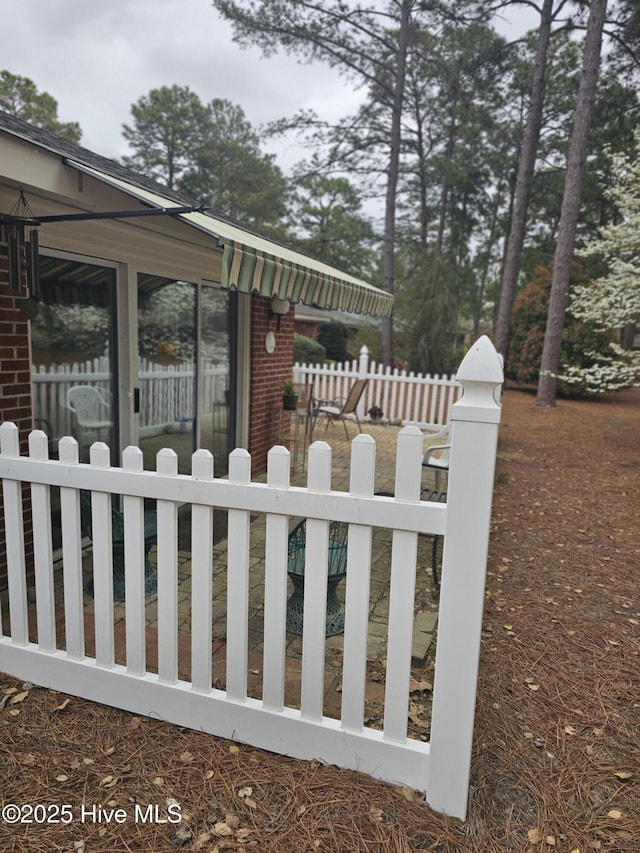 view of property exterior featuring brick siding and fence