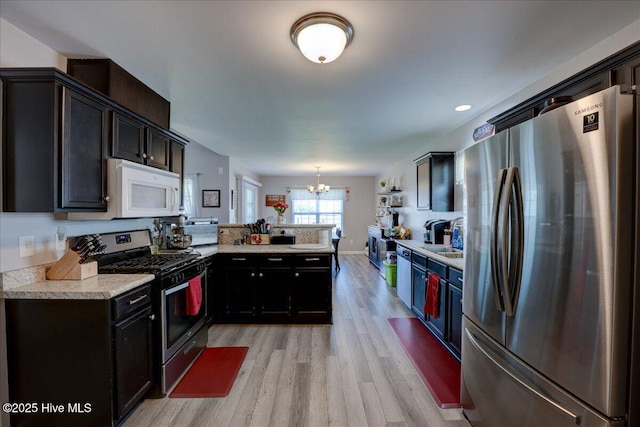 115 Kenmore Ct, New Bern, NC 28560 - kitchen with a chandelier, light countertops, a peninsula, light wood-style flooring, and appliances with stainless steel finishes