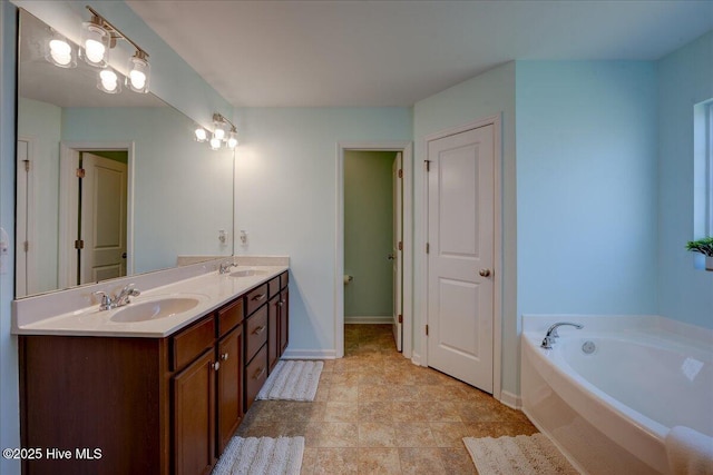 115 Kenmore Ct, New Bern, NC 28560 - bathroom featuring a garden tub, a sink, double vanity, and baseboards