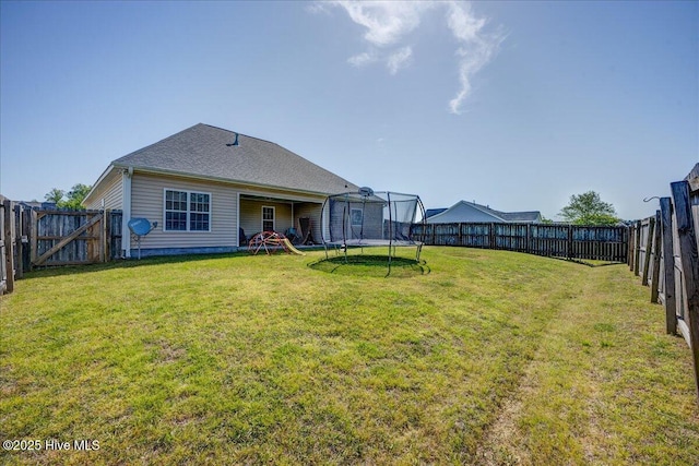 115 Kenmore Ct, New Bern, NC 28560 - rear view of house with a trampoline, a lawn, and a fenced backyard
