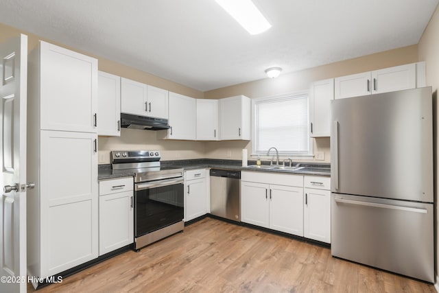 1507 Brookfield Rd, Rockingham, NC 28379 - kitchen featuring stainless steel appliances, under cabinet range hood, dark countertops, and white cabinetry