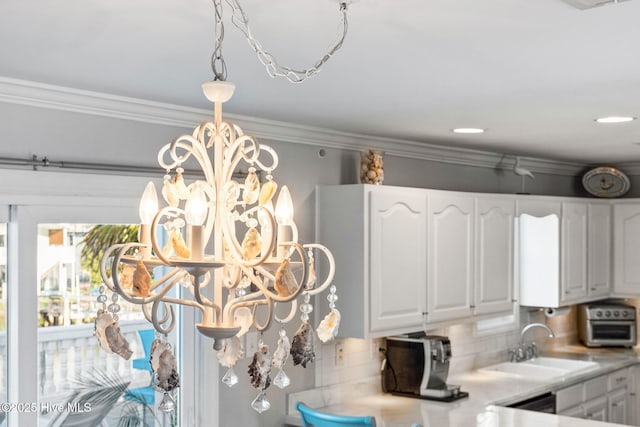 interior details featuring decorative backsplash, a sink, and white cabinets