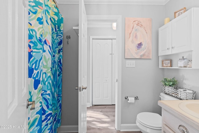 full bathroom featuring vanity, ornamental molding, toilet, wood finished floors, and baseboards