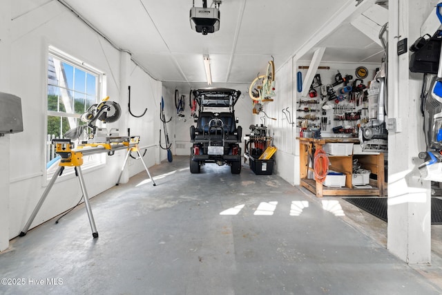 garage with a garage door opener and a workshop area