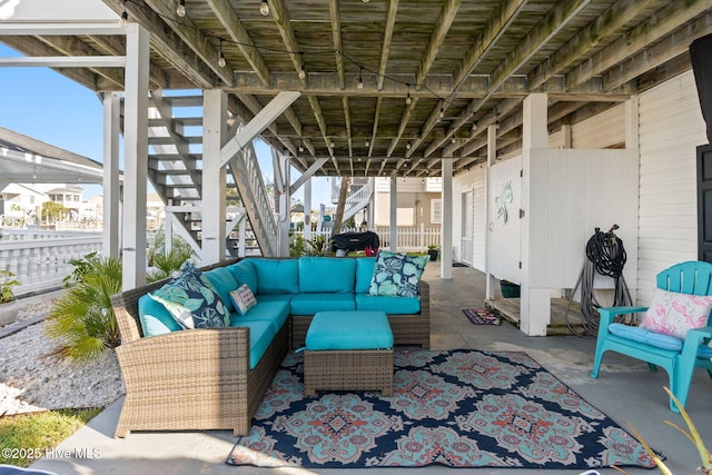 view of patio with an outdoor living space, stairway, and fence