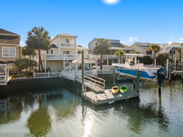 view of dock featuring boat lift, a residential view, and a water view