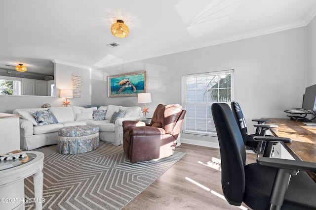 living area featuring light wood-style flooring, crown molding, and visible vents