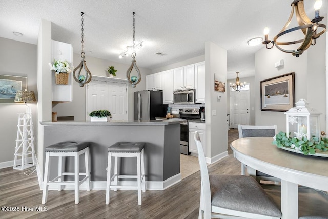 1135 Park Rd SW Unit 1203, Sunset Beach, NC 28468 - kitchen with appliances with stainless steel finishes, a kitchen breakfast bar, a peninsula, tasteful backsplash, and light wood-style flooring