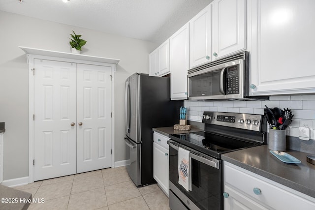 1135 Park Rd SW Unit 1203, Sunset Beach, NC 28468 - kitchen with appliances with stainless steel finishes, dark countertops, tasteful backsplash, white cabinets, and a textured ceiling