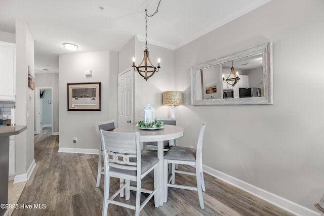 1135 Park Rd SW Unit 1203, Sunset Beach, NC 28468 - dining room with a chandelier, light wood-style flooring, baseboards, and ornamental molding
