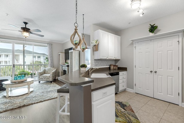 1135 Park Rd SW Unit 1203, Sunset Beach, NC 28468 - kitchen featuring a textured ceiling, dishwasher, a sink, white cabinets, and ceiling fan