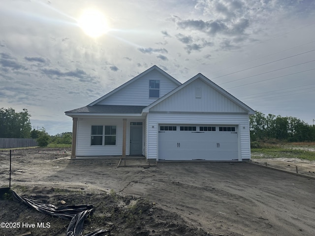 view of front of property featuring an attached garage, covered porch, and driveway
