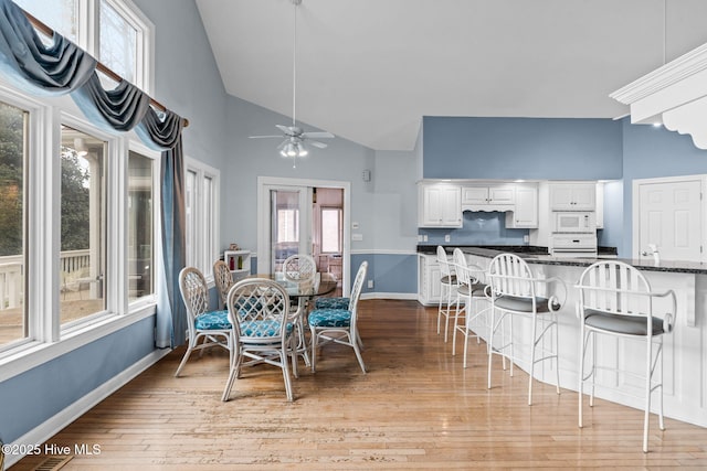 178 Edgewater Cir, Sunset Beach, NC 28468 - dining space with ceiling fan, light wood-type flooring, high vaulted ceiling, and baseboards