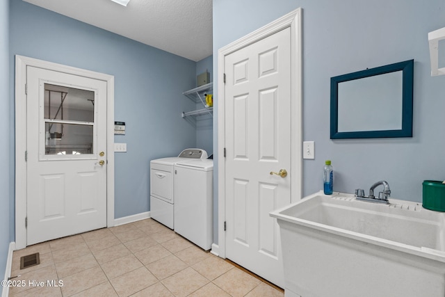 178 Edgewater Cir, Sunset Beach, NC 28468 - laundry room featuring light tile patterned flooring, visible vents, laundry area, washer and dryer, and a sink