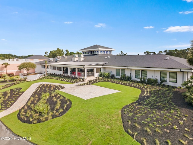178 Edgewater Cir, Sunset Beach, NC 28468 - view of front of house with a patio, stucco siding, and a front lawn