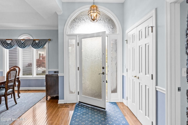 178 Edgewater Cir, Sunset Beach, NC 28468 - entryway with a notable chandelier, baseboards, crown molding, and wood finished floors