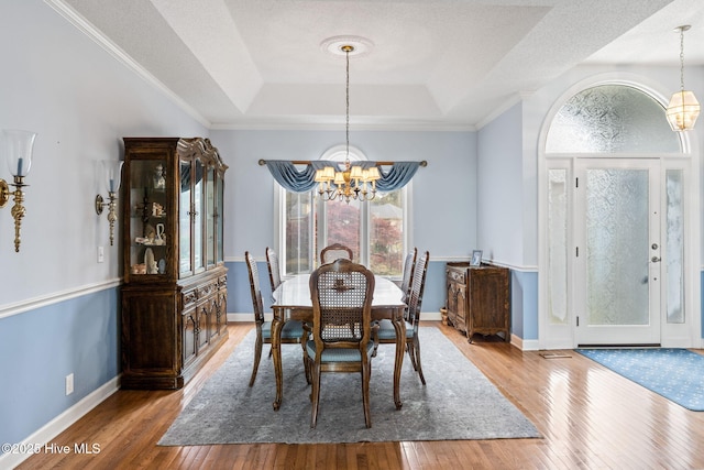 178 Edgewater Cir, Sunset Beach, NC 28468 - dining room featuring a chandelier, wood-type flooring, baseboards, and a tray ceiling