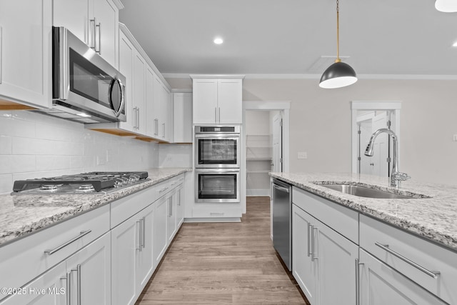 804 Winds Way, Aberdeen, NC 28315 - kitchen featuring appliances with stainless steel finishes, white cabinets, decorative backsplash, hanging light fixtures, and light wood-style floors