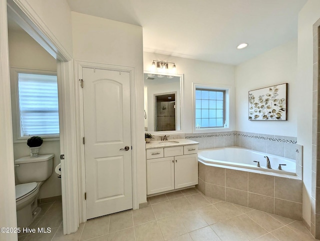 bathroom featuring a garden tub, toilet, vanity, and tile patterned floors