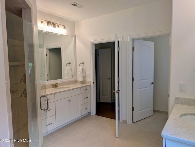 bathroom featuring vanity, tile patterned floors, a stall shower, and visible vents